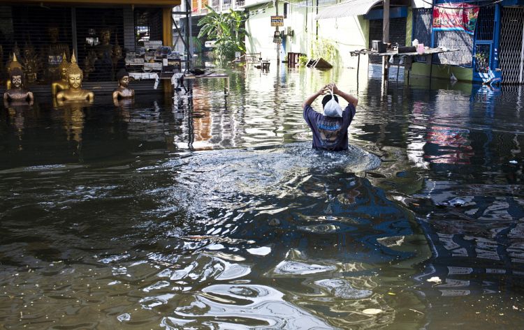 man wades through a flood water