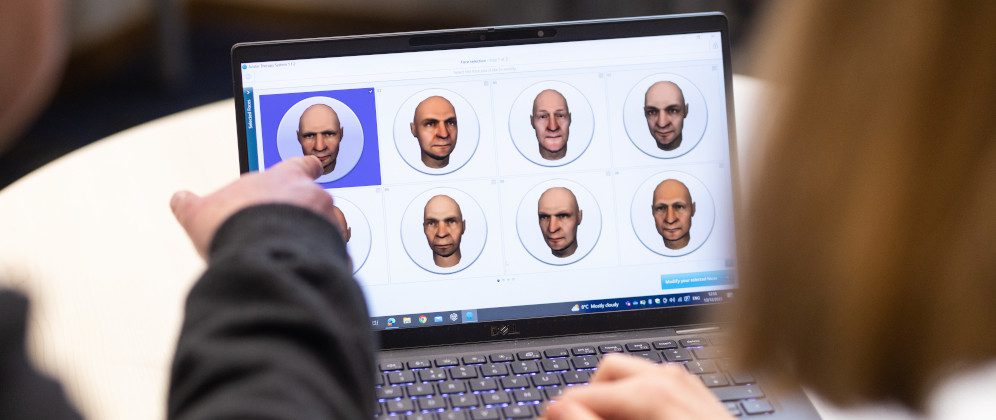 A participant speaks face-to-face with an avatar in the trial of an AI-powered therapy for people who hear voices in their heads. Copyright: Jason Alden Photography Ltd / Wellcome. This image is intended for illustrative purposes only and does not depict an actual therapy session.