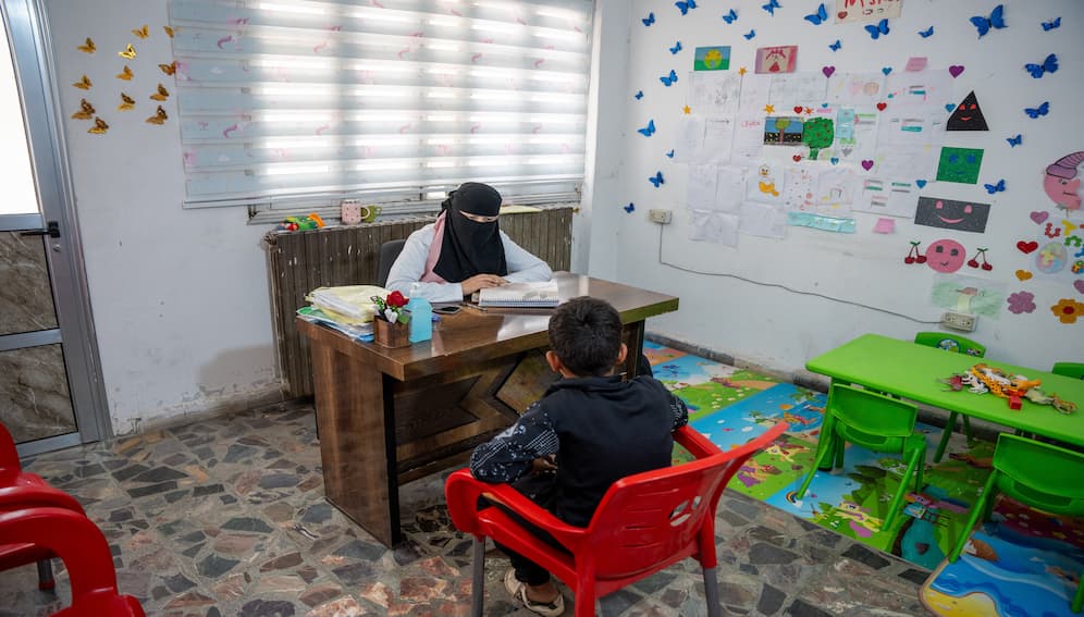A psychologist provides a support session to a displaced child at a center in Syria