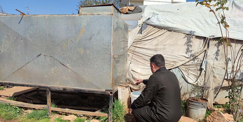 Hussein Al-Nahlawi collects water from a tap at Qah camp, northern Syria, where USAID previously provided free drinking water. Credit: Sonya Alali| Story: loss of USAID funding is putting millions of lives at risk around the world
