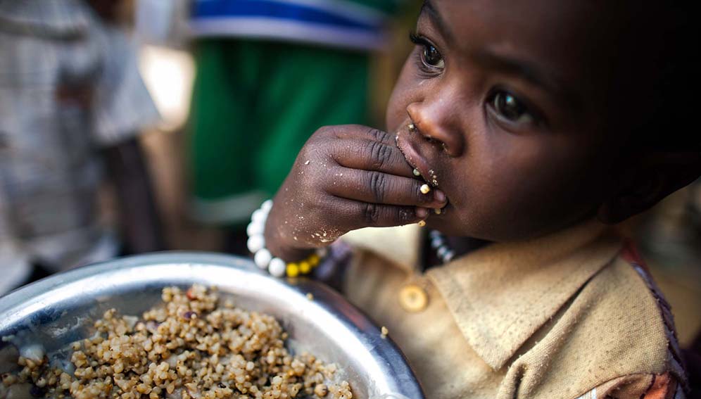 A child eats lentils in a food distribution center in the Rwanda camp for internally displaced people (IDP) in Tawila, North Darfur. - UNAMID Photo CC BY-NC-ND 2.0 (https://creativecommons.org/licenses/by-nc-nd/2.0/)